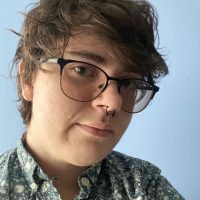 Cole Sorensen, a light skinned person with short dark hair and tinted glasses